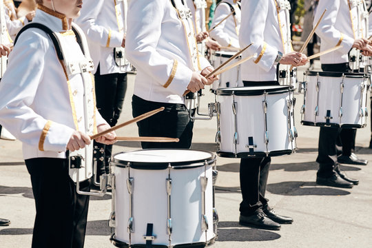 The ensemble of drummers in white ceremonial dress, performing in the spring in the city park.