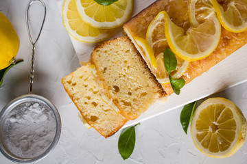 sliced homemade lemon cake decorated with lemon slices in sugar syrup. The porous structure of the cake. The view from the top.