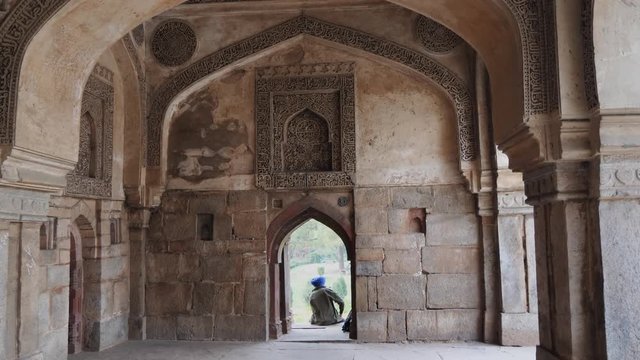 interior view of a bara gumbad window and sikh man sitting on it at lodhi gardens in delhi, india- 4K 60p
