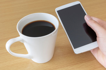 Fototapeta na wymiar スマートフォンを操作しながらコーヒーを飲む
