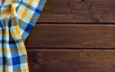 Blue checkered picnic cloth on brown wooden table.
