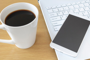 Obraz na płótnie Canvas ノートパソコンを操作しながらコーヒーを飲む