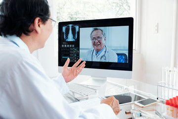 Doctor consulting coworker via video conference