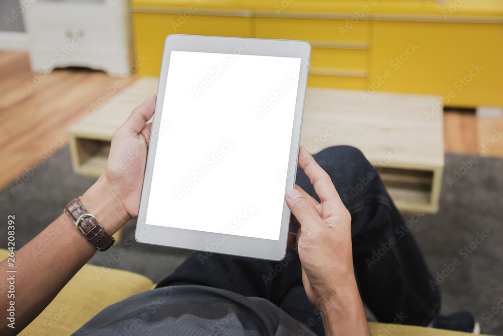 Sticker mockup tablet on businessman hands empty display on home table with blur background. - image - image