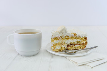 Cup of coffee and piece of cake on wooden table