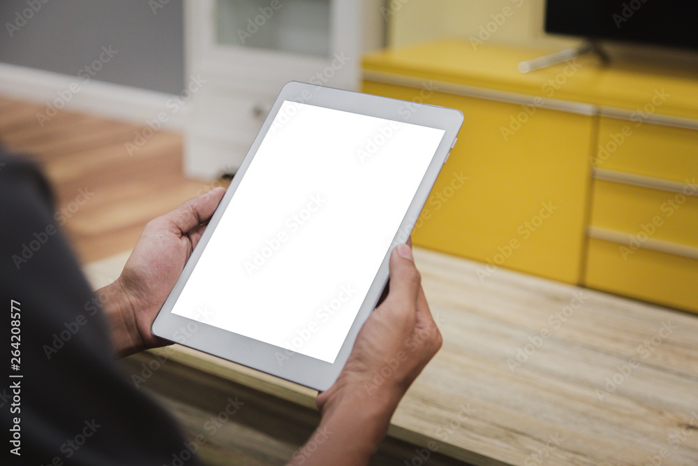 Wall mural mockup tablet on businessman hands empty display on home table with blur background. - image - image