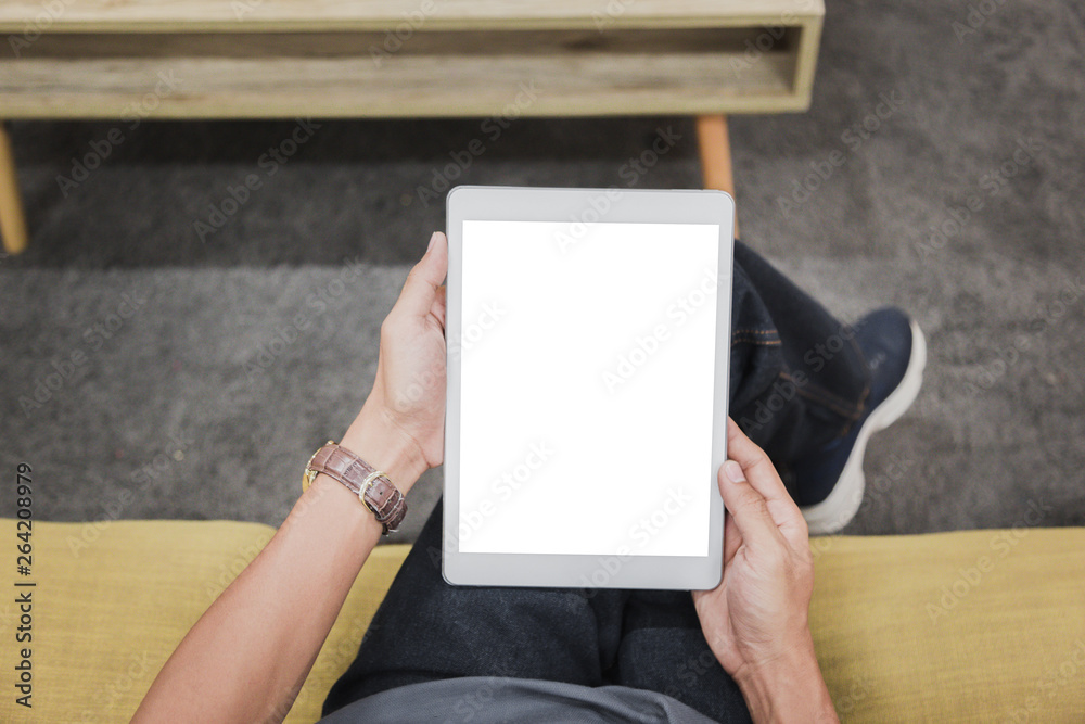 Wall mural mockup tablet on businessman hands empty display on home table with blur background. - image - image