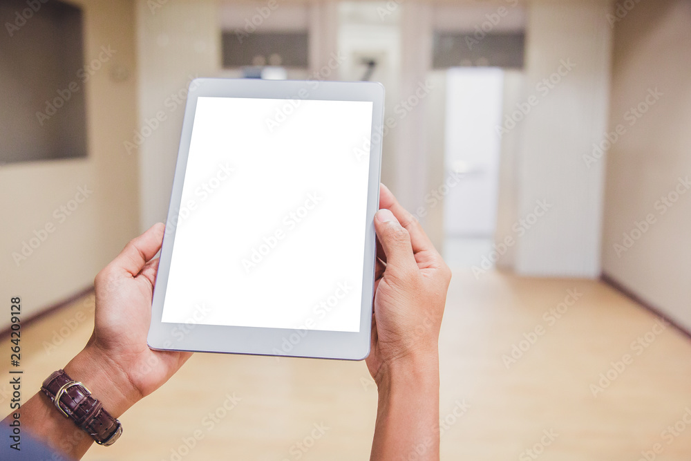 Wall mural mockup tablet on businessman hands empty display on home table with blur background. - image - image