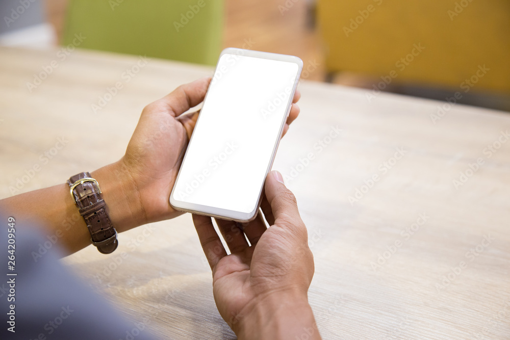 Wall mural mockup smartphone on businessman hands empty display on home table with blur background. - image - i
