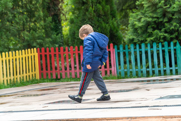 Small child scratching his bottom at a park