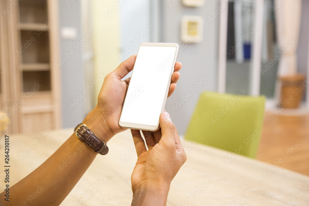 Wall mural mockup smartphone on businessman hands empty display on home table with blur background. - image - i