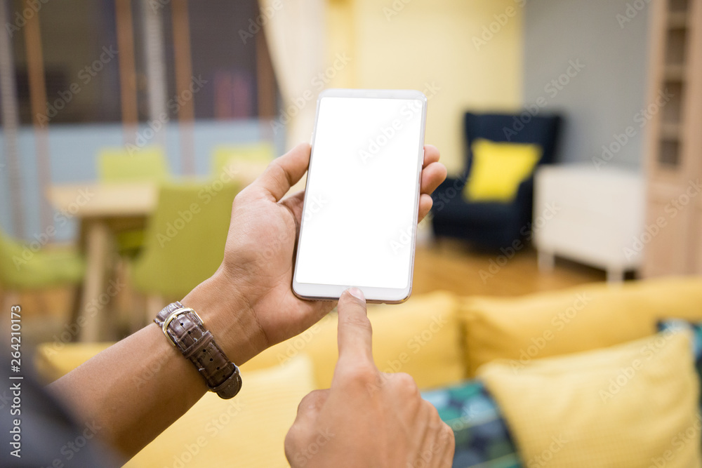 Wall mural mockup smartphone on businessman hands empty display on home table with blur background. - image - i