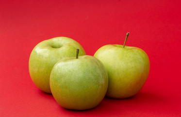 Green apple on red background