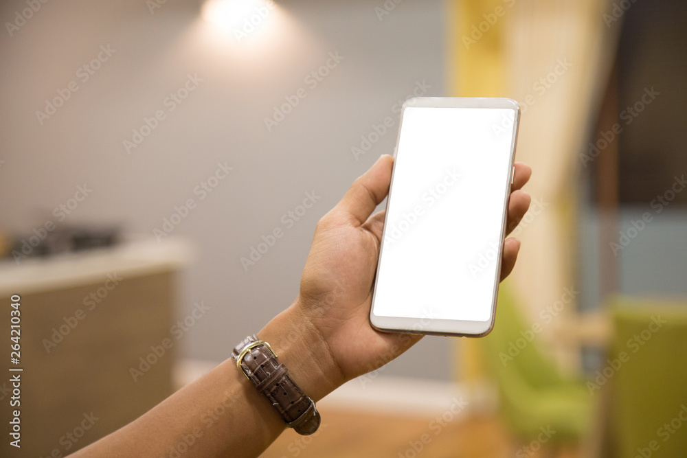 Wall mural mockup smartphone on businessman hands empty display on home table with blur background. - image - i