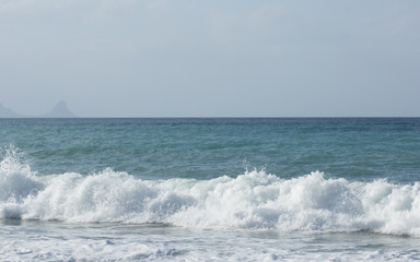 Naklejka na ściany i meble Scenic view of waves on sea beach and blue sky