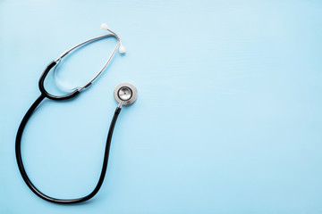 Stethoscope on pastel blue table. Doctor tool for heartbeat and noise of lungs listening....