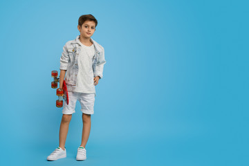 Confident trendy boy with skateboard