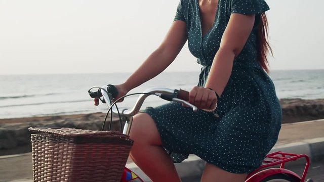 Close up red hair female ride vintage bicycle and look in a camera slow motion