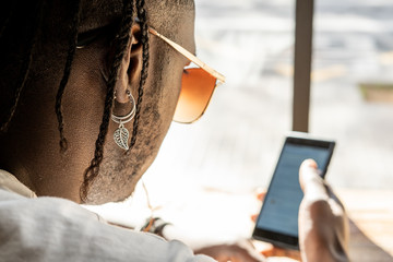 Handsome african american looking at a mobile phone in a coffee shop