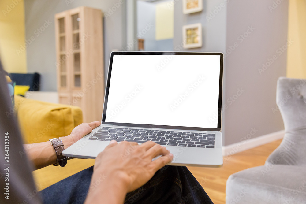 Wall mural mockup image of a businessman using laptop with blank white desktop screen working in home- image