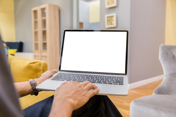 Mockup image of a businessman using laptop with blank white desktop screen working in home- Image