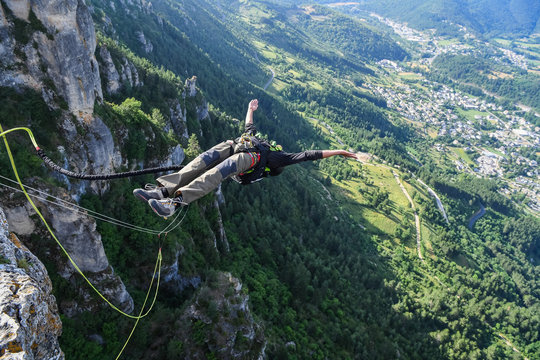a man doing bungee jump from a cliff, Occitanie, Florac, France