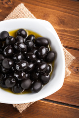 Black olives on wooden background