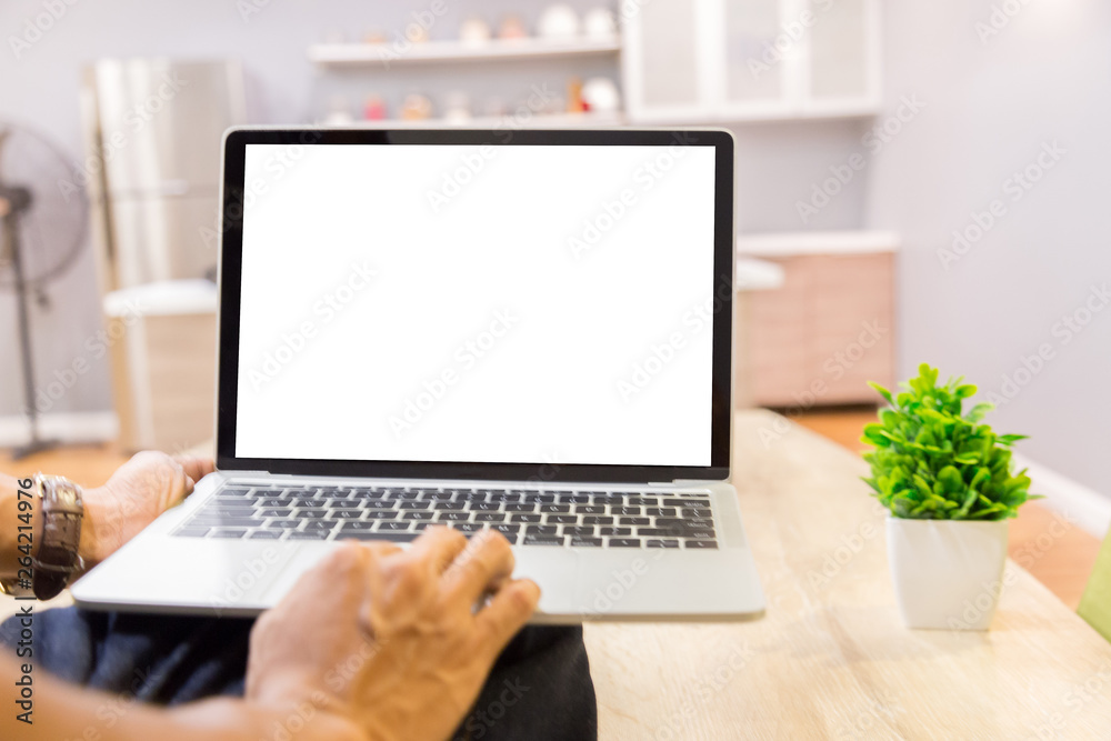 Wall mural mockup image of a businessman using laptop with blank white desktop screen working in home- image