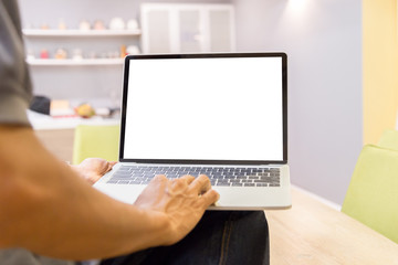 Mockup image of a businessman using laptop with blank white desktop screen working in home- Image