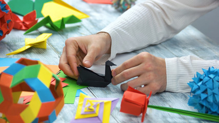 Origami paper swans. Close up. Male hands, origami master.