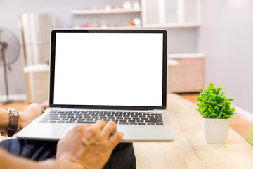 Mockup image of a businessman using laptop with blank white desktop screen working in home- Image