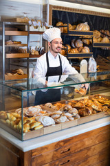 Man baker showing warm tasty croissant