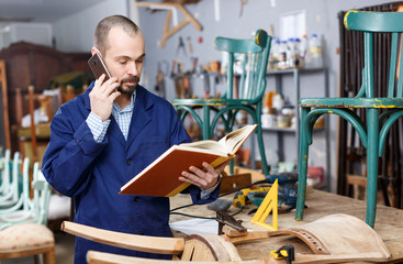 Restorer holding album and talking on phone