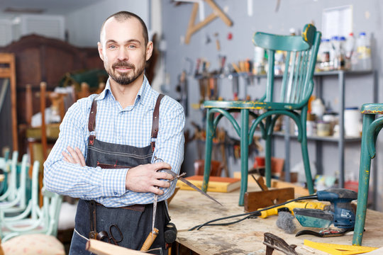 Carpenter Standing In Furniture Repair Shop