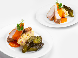 Duck of turkey breast, pork chops, cooked sous vide, crushed potatoes, bacon, baked pepper sauce, pickled cucumber salad.