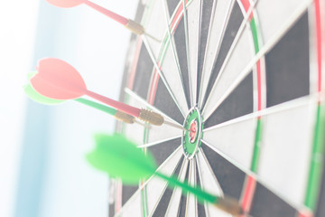 Dartboard on a blue background with arrows hitting the center target