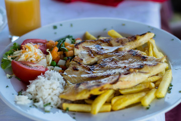 Grilled chicken breast, French fries and vegetables