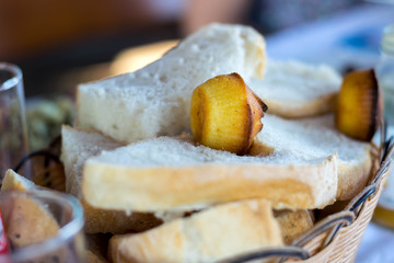 Fresh sliced white bread in the basket on the wooden table in the kitchen