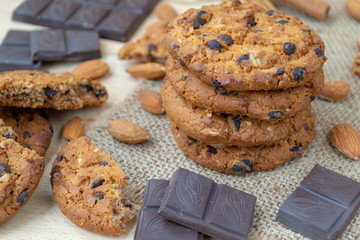 Oatmeal cookies with chocolates and nuts on a wooden table.