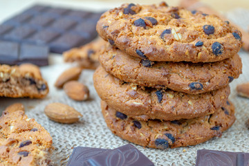 Oatmeal cookies with chocolates and nuts on a wooden table.