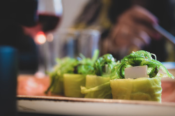 A plate of healthy sushi with blurred background of the inside of a restaurant. 