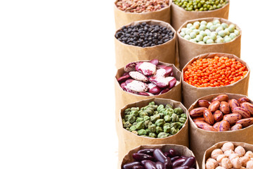 Various assortment set of indian legumes in paper sack bags isolated on white background.