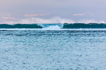Ocean surf on the sunset glow background on Mauritius island seashore