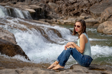 Girl sitting in front of small waterfall