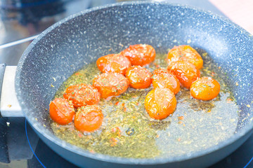 Tomatoes are fried in a pan