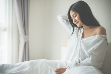 Beautiful young woman wake up in the morning at bedroom