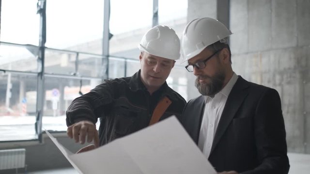 Two Engineers Meet At Construction And Consult Building Project. Two Engineers. 4k