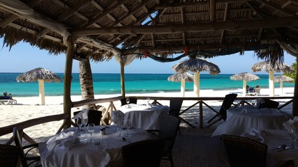 Tropical Beach Restaurant Shack with Ocean View, White Sand and Palapas. Relaxed Caribbean Resort Hotel Outdoor Dining. Playa Esmeralda, Guardalavaca, Cuba.