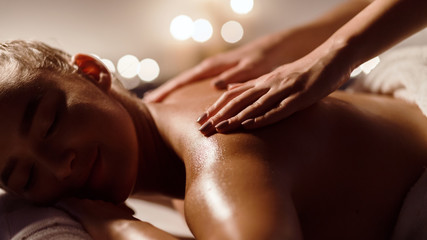 Girl receiving back massage in spa salon