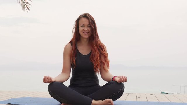 dolly shot portrait of female sitting in meditation pose and twink on yoga mat